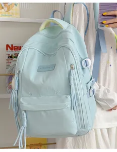 Leuke lichte blauwe schoolrugzak detail met strik borduurwerk en kwastjes voor meisjes.