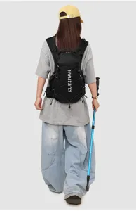 Detail view of lightweight black outdoor sports backpack with breathable straps and bungee cords.