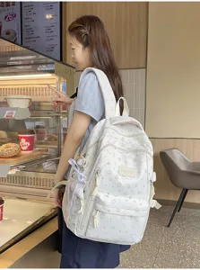 Zijaanzicht van de witte rugzak met sterrenprint in detailweergave van de gezellige caféscène.