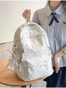 Grote witte schoolrugzak met leuke doodle-print en stijlvolle lint-hangdecoratie.