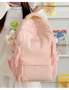 Roze schattige schoolrugzak voor meisjes met strikborduurwerk, grote capaciteit en leuke hangerdetails.