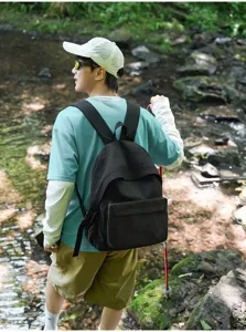 Detail de scene de voyage en plein air d'un sac a dos de loisir noir porte par un modele.