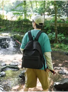 Vue détaillée style de vie en plein air d'un sac à dos noir par un voyageur en forêt.