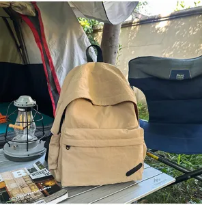 Détail de sac à dos de voyage décontracté en nylon kaki avec design à rabat spacieux.