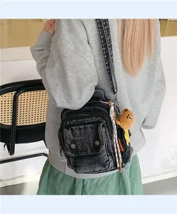 Casual washed black denim backpack for women, stylish crossbody shoulder bag with cute bear pendant.