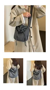 Vue détaillée du sac porté épaule gris foncé à cordon de serrage et bandoulière réglable.