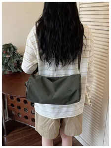 Sac porté épaule cylindrique en nylon décontracté vert foncé avec bandoulière réglable.