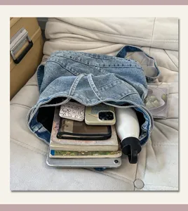Detailed view of large capacity vintage washed denim backpack showing interior compartment storage.