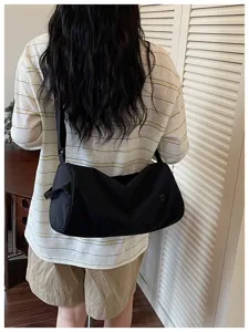 Vue détaillée du sac porté épaule cylindrique en nylon noir avec grande capacité et style.