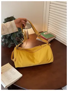 Détail de sac bandoulière cylindrique en nylon jaune décontracté, grand sac cabas quotidien.