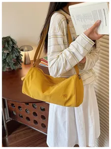Sac bandoulière cylindrique en nylon jaune élégant pour femmes, grande capacité design chic.
