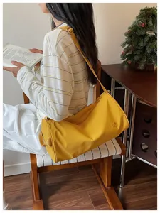 Sac à bandoulière minimaliste en nylon pour femme grande capacité sac cylindrique fourre-tout.