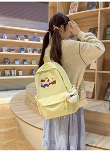 Canvas school backpack detail view, light yellow daily casual bag with cute embroidery.
