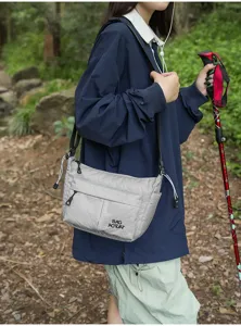 Bolso cruzado de nylon informal al aire libre detalle tela gris texturizada y correa