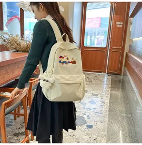 Casual canvas backpack with cute puppy embroidery and plush pendant for daily school use.
