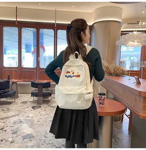 Stylish white canvas backpack for women, casual school bookbag with cute embroidery.