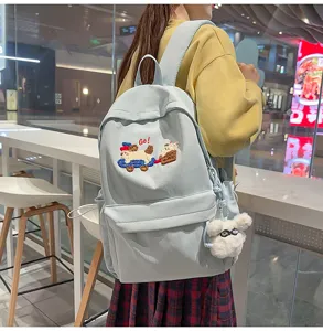 Stylish light blue school backpack for women with cute dog embroidery and fluffy pendant.