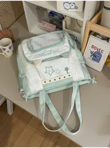 Mintgroene ita tas detail opname, doorzichtig venster, schattige kattenoren en sterrenpatroon.