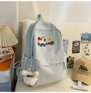 Casual light blue school backpack for students with cute embroidery and fluffy charm design.