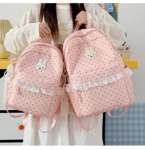 Rosa gepunkteter süßer Schulrucksack mit süßer Spitzenborte und Hasenaufnäher für Schüler.