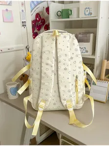 Gedetailleerd uitzicht op de beige rugzak met leuke prints en gele schouderbanden op bureau.