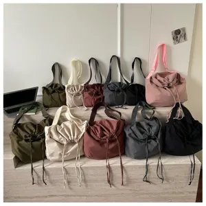 Vue détaillée de plusieurs sacs à bandoulière colorés et à cordon sur des marches.