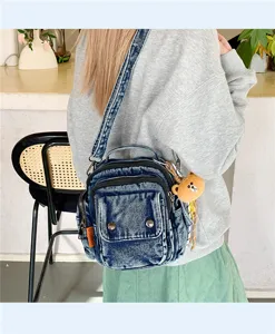 Detailed view of casual denim crossbody bag with multiple pockets and cute bear pendant for daily wear.