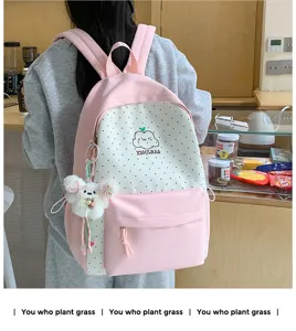 Gedetailleerd overzicht van roze witte polkadot rugzak met schattige wolkprint en berenhanger.