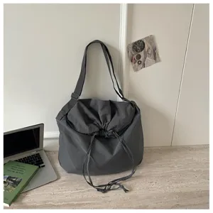 Vue détaillée du sac bandoulière gris foncé avec cordon de serrage et grande capacité souple.