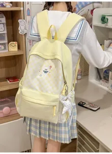 Detail van de gele geruite schoolrugzak met schattig hondenborduursel en leuke strik.
