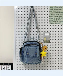 Casual denim crossbody bag with multiple pockets and cute bear charm for daily fashion use.