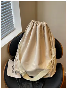 Vue détaillée du sac bandoulière minimaliste à cordon en tissu beige doux de grande capacité.