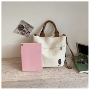 Vue détaillée du sac cabas en toile décontracté avec anses marron et un joli patch.