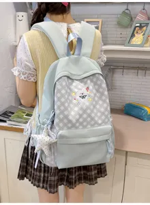Leuke geruite schoolrugzak met schattige berenborduursel en sterhangerdetail in close-up.