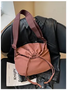 Vue de détail du sac bandoulière unicolore à cordon, sac souple et sac porté épaule.
