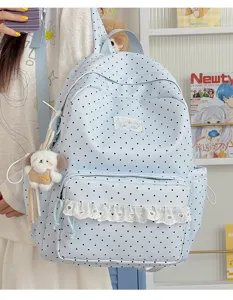 Leuke blauwe stippen rugzak met kanten afwerking en puppy hanger voor school en dagelijks gebruik.
