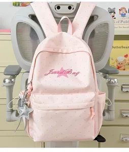 Roze gestippelde schoolrugzak detail met sterhangtje en voorzak in schattige stijl.