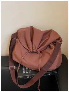 Vue détaillée du sac bandoulière décontracté mettant en valeur le cordon souple et la sangle.