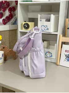Gedetailleerd overzicht van de paars-witte canvas tote tas met zijvak en nette stiksels.