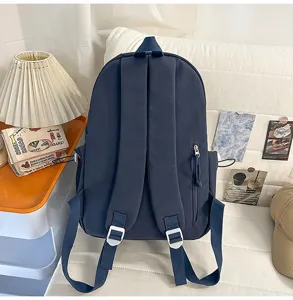 Casual navy blue school backpack detail view with adjustable straps and secure zip pocket.