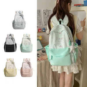 Close-up van schattige Japanse geruite schoolrugzak met ruime capaciteit en leuke hangers.