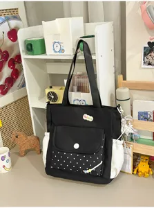 Zwarte canvas tote tas detail, witte stippen voorzak, casual studenten schoudertas.