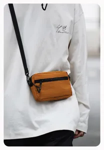 Detail opname van een vintage casual crossbody tas in karamelbruin met zwarte ritsen.