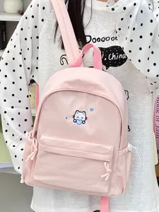 Gedetailleerd overzicht van de roze canvas rugzak met schattig kattenborduurwerk en voorvak.