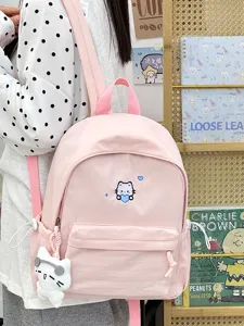 Roze canvas rugzak detail, schattig kattenborduurwerk en pluche hanger voor dagelijks gebruik.