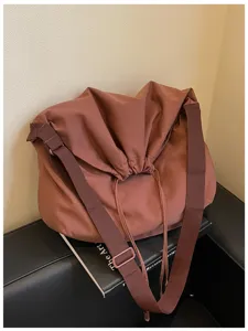 Détail du sac bandoulière marron souple avec sangle large et fermeture à cordon pratique.