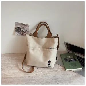 Vue détaillée du sac à bandoulière en toile épaisse de style coréen avec poche avant et broderie.
