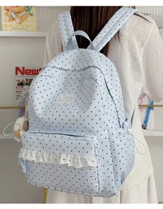 Gedetailleerd overzicht van een schattige lichtblauwe polkadots rugzak met witte kantrand en voorvak.