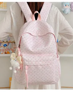 Gedetailleerd uitzicht op de roze polkadot studentenrugzak met konijnenprint en pluche hanger.