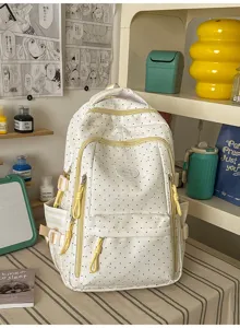 Detailopname van een schattige witte rugzak met stippen en gele ritsen in een stijlvolle kamer.